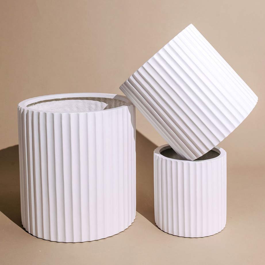 Three sizes of rib-textured white pots stacked.